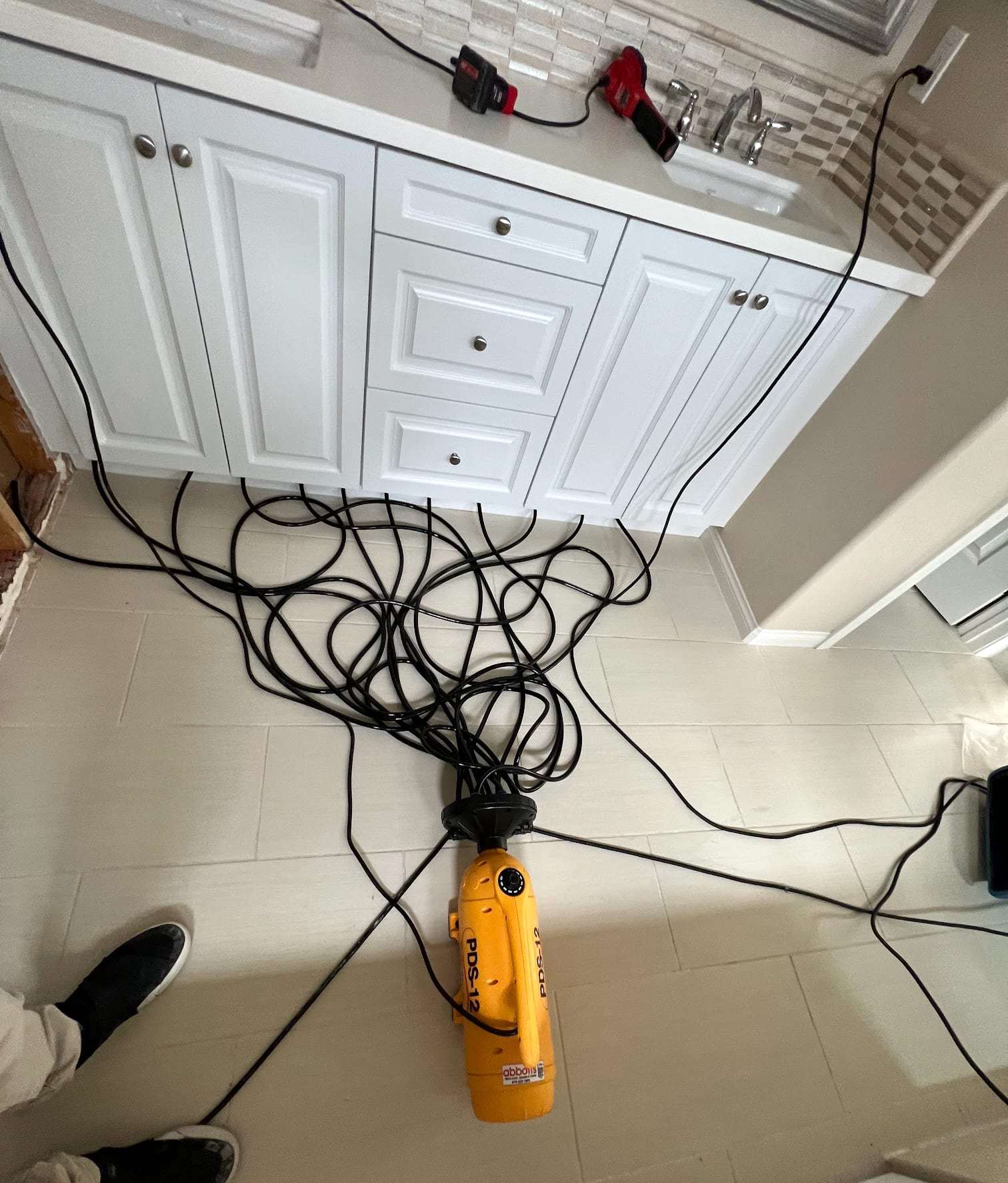 Bathroom vanity with hoses feeding a cabinet drying system